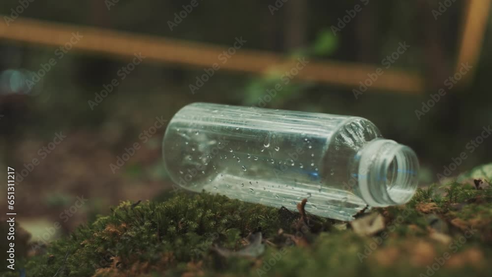 Close up of a forensic police investigator putting checking for fingerprints on an bottle on a crime scene in the woods Close up of a forensic police investigator putting checking for fingerprints on an bottle on a crime scene in the woods