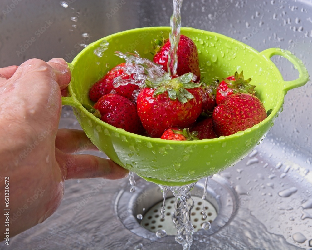 Φωτογραφία Rinsing strawberries in colander under water stream