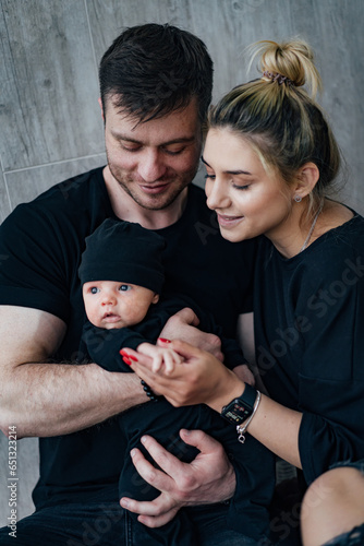Young new family portrait. Smiling pretty parents with newborn baby.
