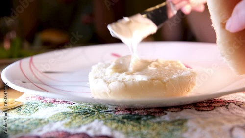 spread the bun with mayonnaise start preparing the burger light food fast food with knife spread the bread on the plate photo