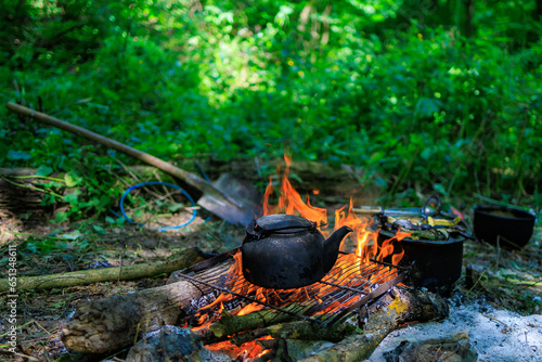 Kettle on campfire. Camping or hiking. Background with selective focus