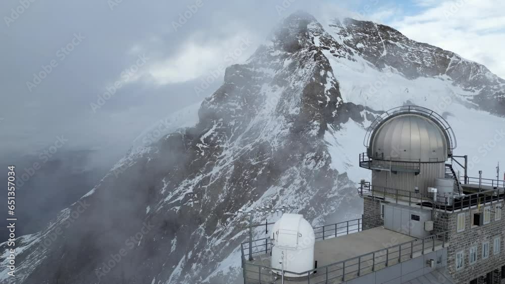 Drone footage flying backwards to reveal metal and glass observatory