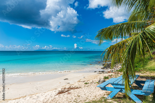 Caribbean landscape with a blue bench in foreground and an idyllic sea in backgorund. Tropical seascape.