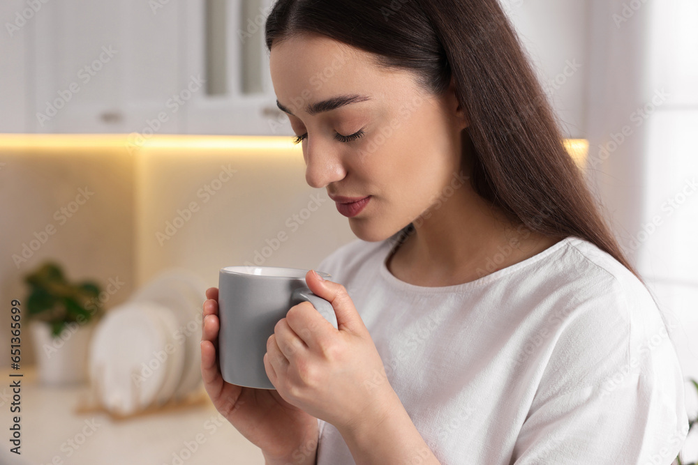 Beautiful woman with cup of drink in kitchen, space for text. Lazy morning Beautiful woman with cup of drink in kitchen, space for text. Lazy morning