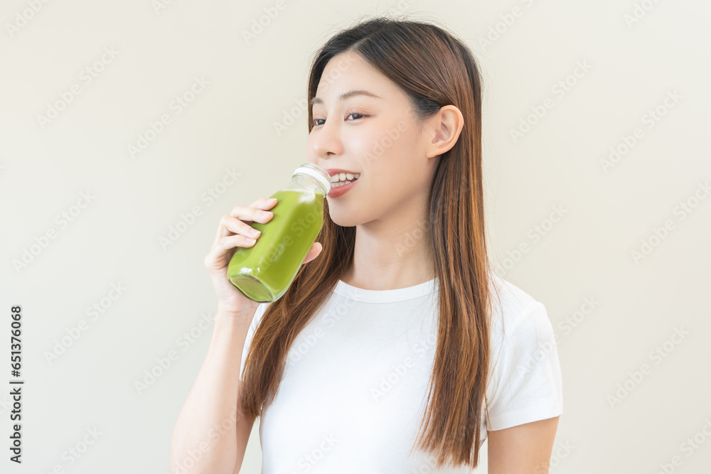 Green detox juice concept, Beautiful asian young woman hand holding vegetable smoothie bottle for diet on background. Happy girl drinking healthy meal food for weight loss. Lifestyle, vegan nutrition. Green detox juice concept, Beautiful asian young woman hand holding vegetable smoothie bottle for diet on background. Happy girl drinking healthy meal food for weight loss. Lifestyle, vegan nutrition.
