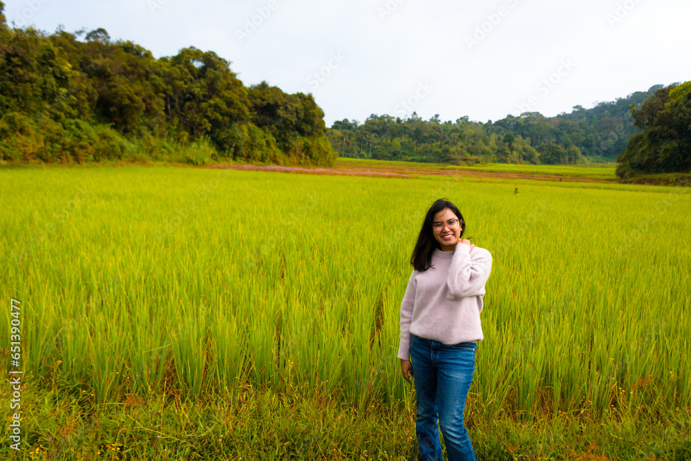Enjoying the nature. Beautiful and young Indian woman enjoying the fresh air in green paddy farm. Enjoying the nature. Beautiful and young Indian woman enjoying the fresh air in green paddy farm.