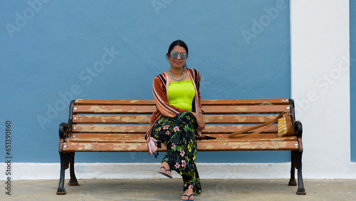 Beautiful young Indian woman sitting on a bench
