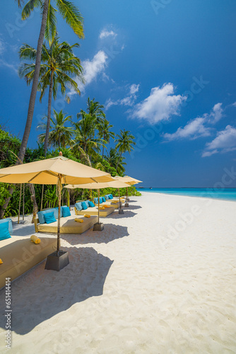Amazing beach. Romantic chairs umbrella on sandy beach palm leaves  sun sea sky. Summer holiday  couples vacation. Love happy tropical landscape. Tranquil island coast relax beautiful landscape design