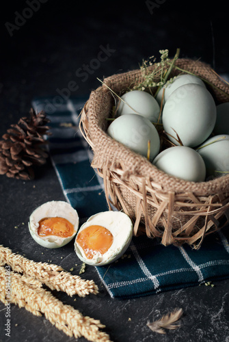 salted eggs, duck eggs in the bamboo basket and sackcloth with dark background. split salted eggs. photo