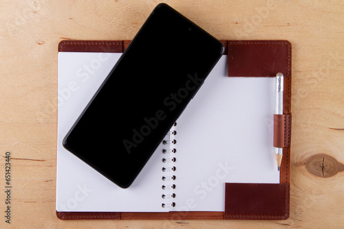 Digitalization concept. Paper notebook vs smartphone. photo