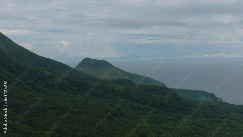 Mountains and green hills in Camiguin Island. Slopes of mountains with evergreen vegetation. Philippines.
