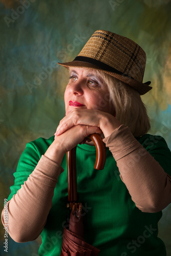 Model in a hat and jacket. Emotional look. Artistic background.