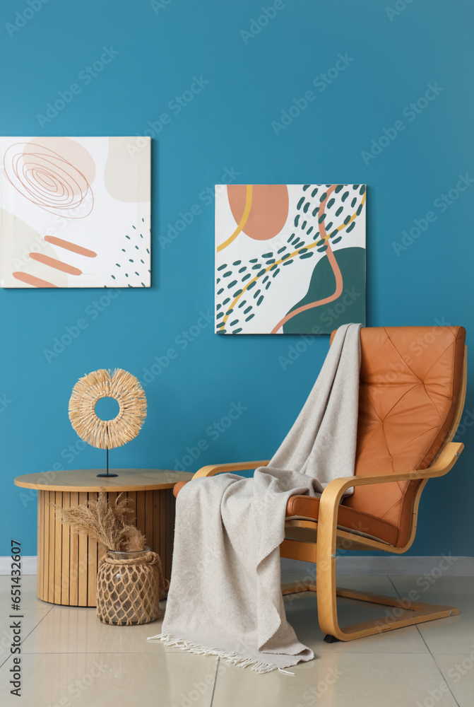 Obraz premium Interior of living room with plaid on armchair and table