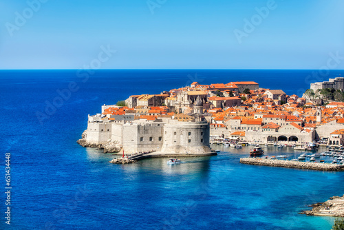 Fototapeta Naklejka Na Ścianę i Meble -  Small Boat Leaving the Harbor of Dubrovnik, Croatia, with St John's Fortress and the Old City