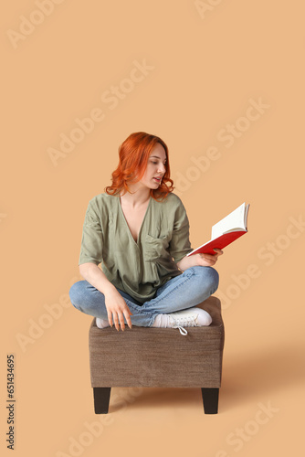 Young woman reading book on...