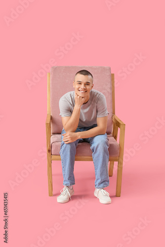 Happy young man sitting on ...