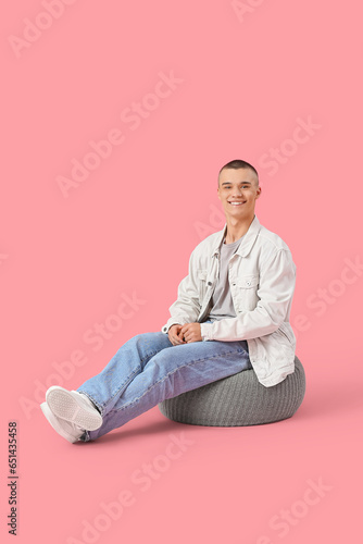 Happy young man sitting on ...
