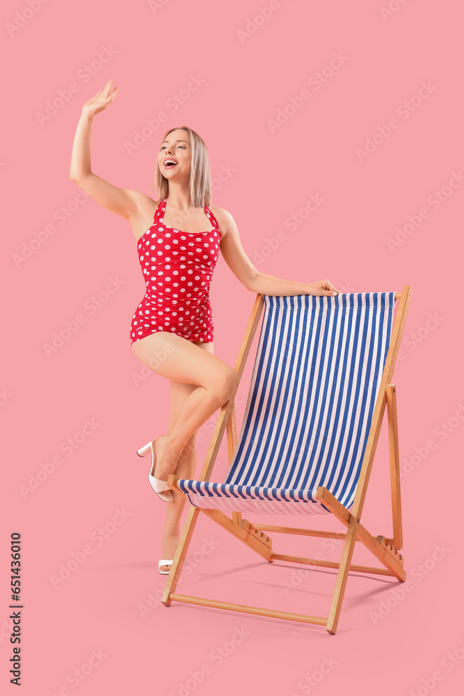 Beautiful young woman with deck chair on pink background Beautiful young woman with deck chair on pink background
