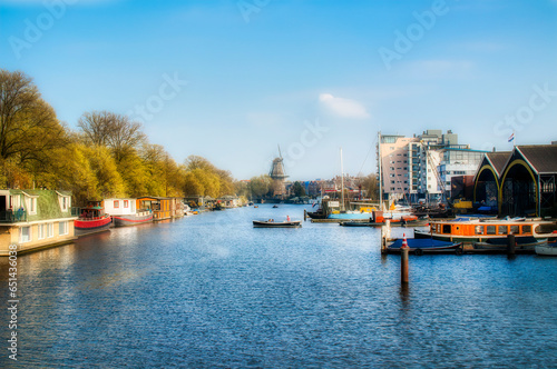 The Nieuwe Vaart Canal in Amsterdam, Holland, with the De Gooyer Windmill in the Background photo