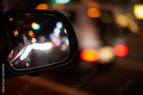 車のサイドミラーから見た夜の都市の夜景の風景