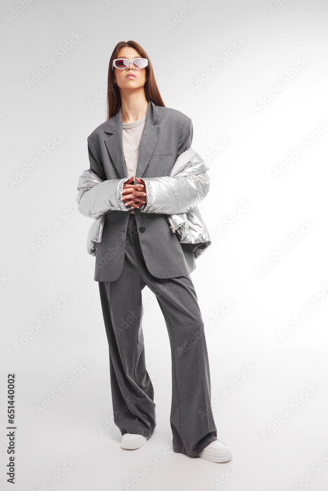 Fashion asian female model in silver down jacket and grey suit. Fashion asian female model in silver down jacket and grey suit.