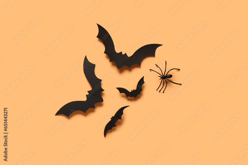 Paper bats and spider for Halloween party on orange background