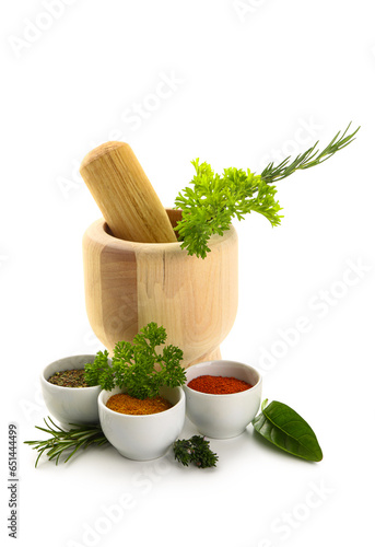 Bowls of spices, herbs and mortar on white background