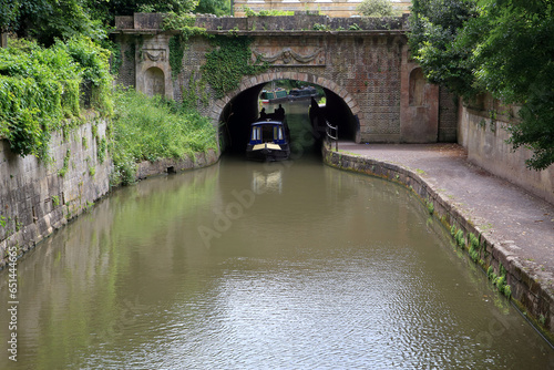 Obraz na płótnie Narrow boat coming out from the Cleveland House Tunnel on the Kenet and Avon canal, witch passes through the Sydney Garden, in Bath, Unted Kingdom