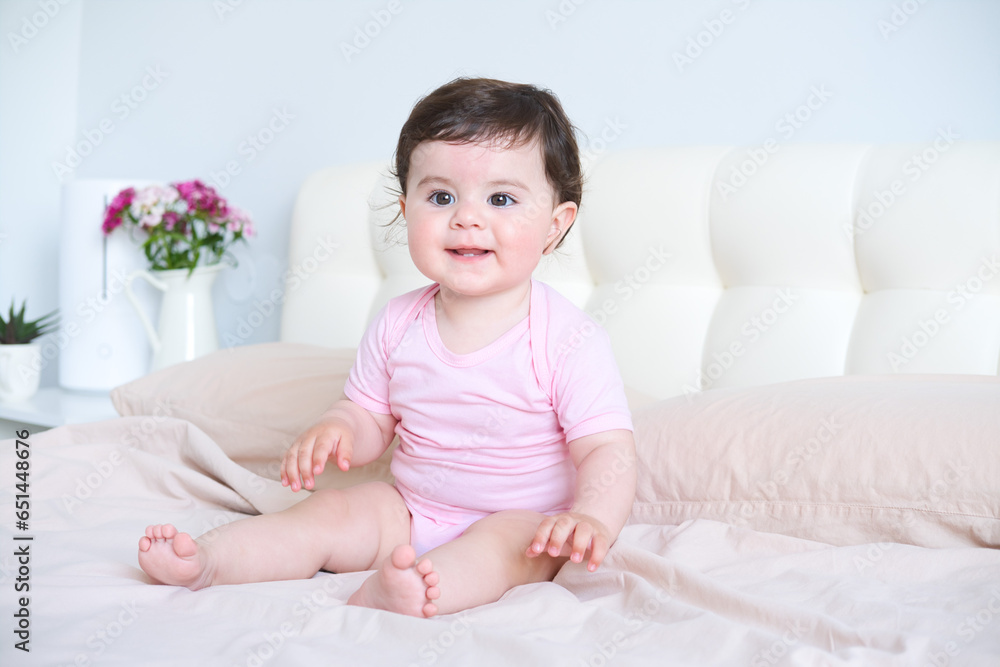 portrait of smiling healthy baby in pink bodysuit on bed portrait of smiling healthy baby in pink bodysuit on bed
