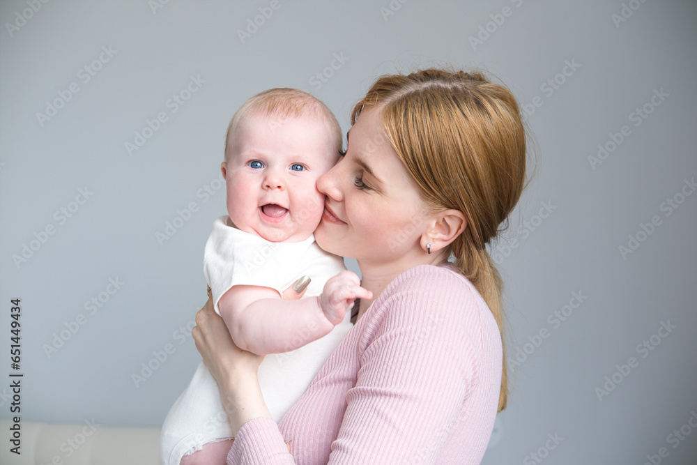 young mother holds her smiling baby in her arms at home young mother holds her smiling baby in her arms at home