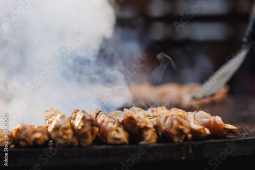 Cook grills chicken kebab steaks open fire. Concept Summer Street food festival