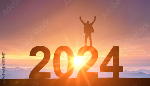 2024. New Year 2024. Man standing at top of data 2024 as sun begins to set. Success Business Leadership. Goals, hopes and aspirations concept. Male silhouette on sunrise background photo