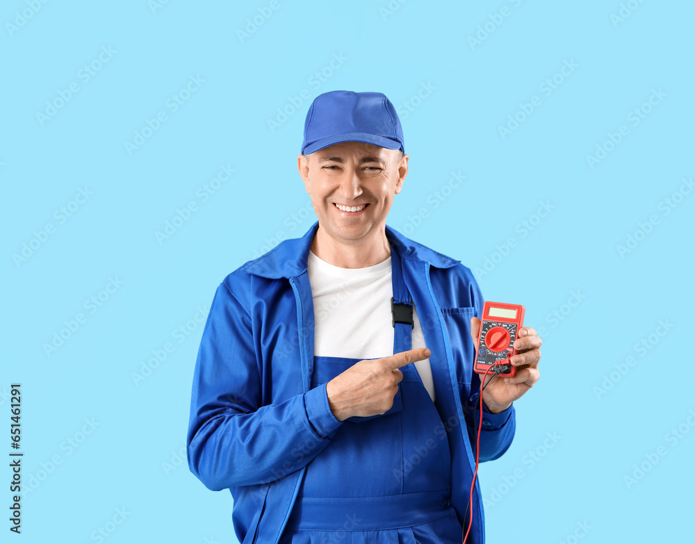 Mature worker with multimeter on blue background. Labor Day celebration Mature worker with multimeter on blue background. Labor Day celebration