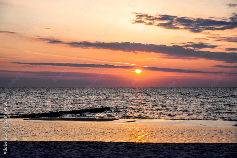 Naklejka premium Sunset on the Baltic Sea in Poland. Landscape in the evening with setting sun by the sea.