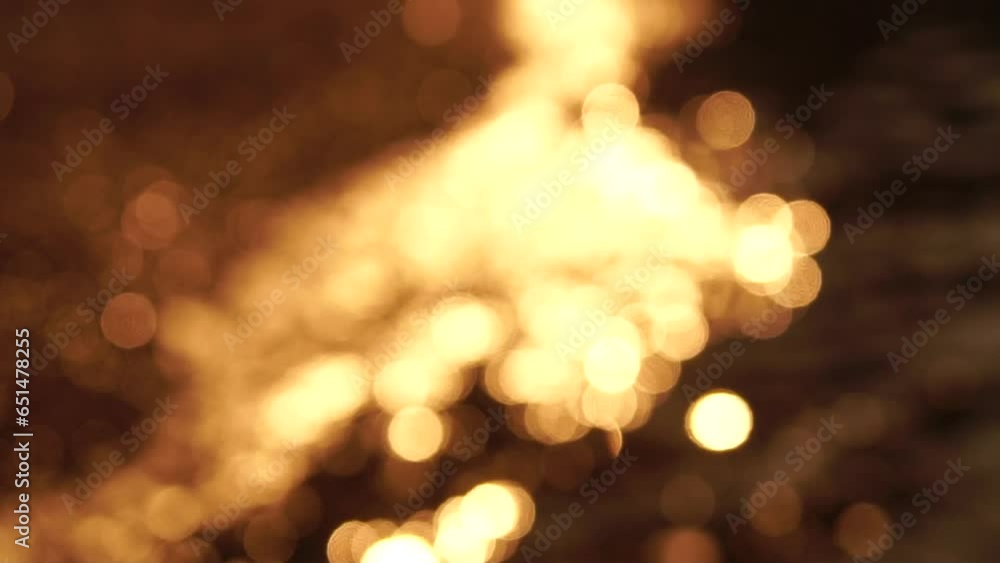 Abstract calm sea summer ocean sunset nature background. Small waves on water surface in motion blur with golden bokeh lights from sun. Holiday, vacation and recreational concept. Slow motion Abstract calm sea summer ocean sunset nature background. Small waves on water surface in motion blur with golden bokeh lights from sun. Holiday, vacation and recreational concept. Slow motion