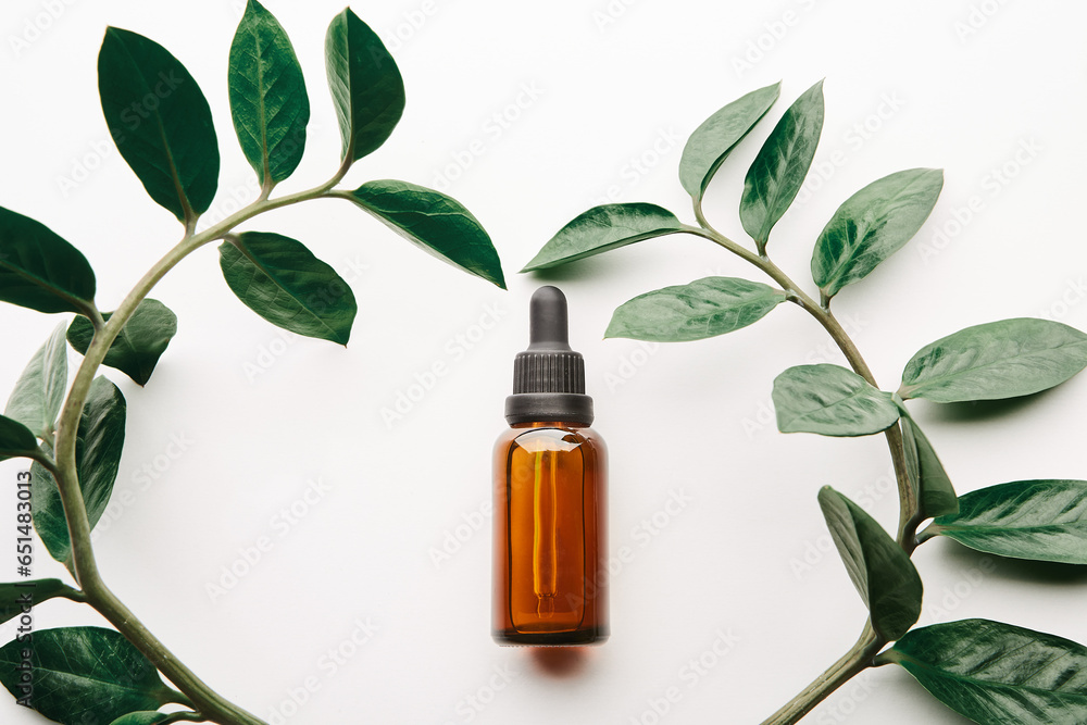 Amber dropper bottle lying inside floral heart. Amber dropper bottle lying inside floral heart.