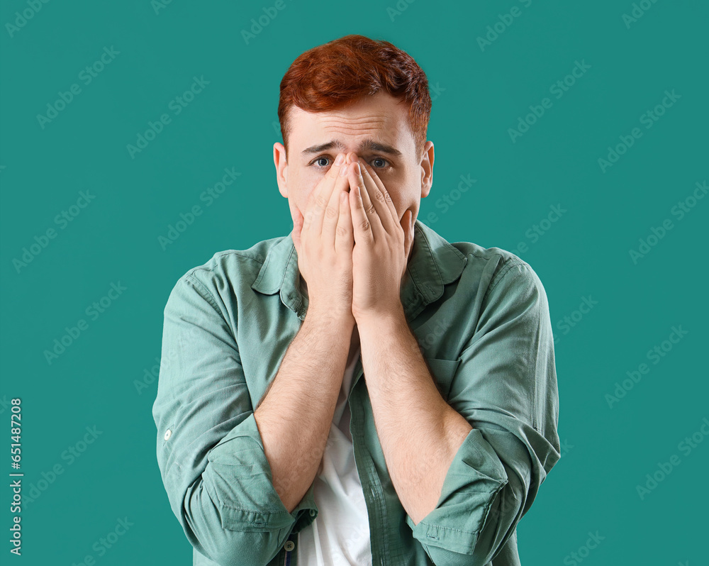 Fearful young man on green background Fearful young man on green background