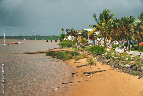 A city beach in Saint-Laurent-du-Maroni lined with palm trees and yachts in a the South American country of French Guiana. photo
