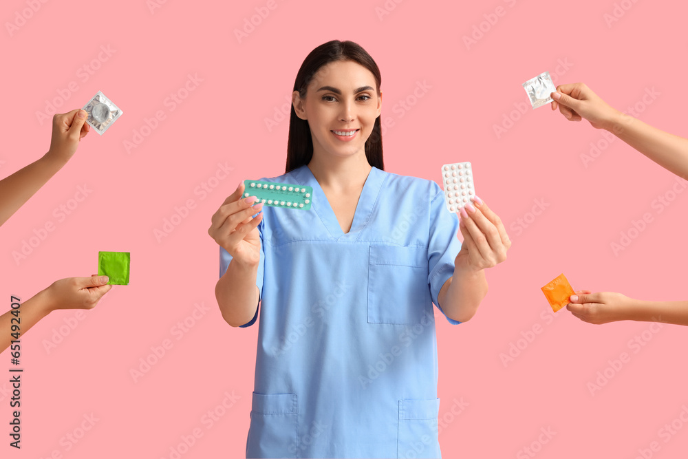 Female gynecologist and hands with contraceptives on pink background