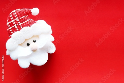 Red cute mini Santa Claus on red copy space background, concept of joyful Christmas party is coming soon, festive season decoration with holiday cute elements