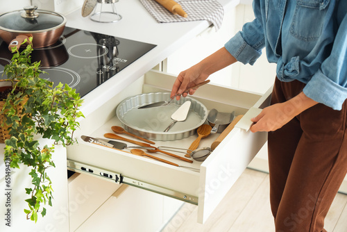 Woman putting spatula into ...