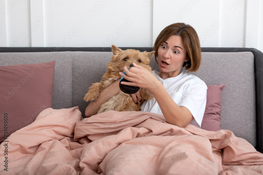 Young shocked woman waking up too late and her cute dog doesn't help her Young shocked woman waking up too late and her cute dog doesn't help her
