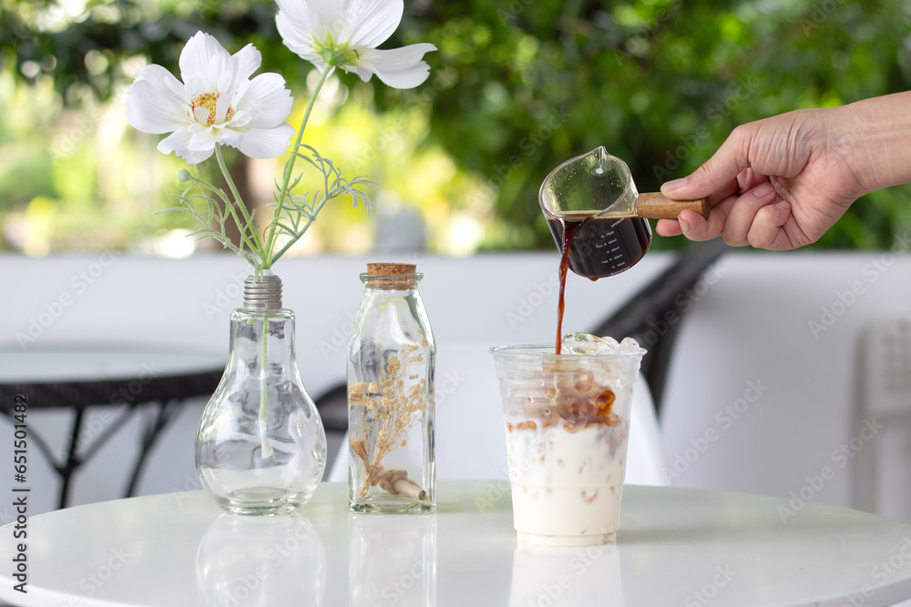 person pouring coffee into glass person pouring coffee into glass