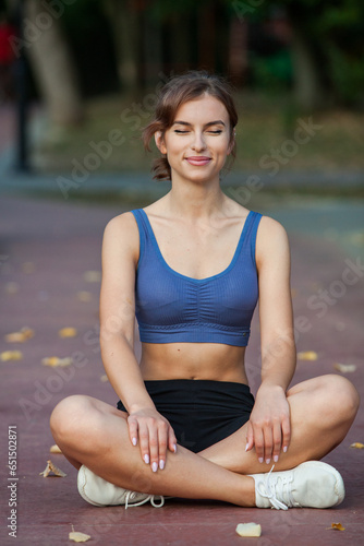 Athletic young woman in sportswear jogging in the park. Fitness and healthy lifestyle. Portrait of a beautiful young woman in sportswear outdoors. Sport fitness model caucasian ethnicity training.