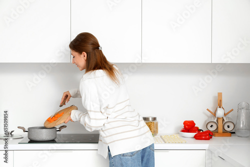 Young woman cooking chicken...