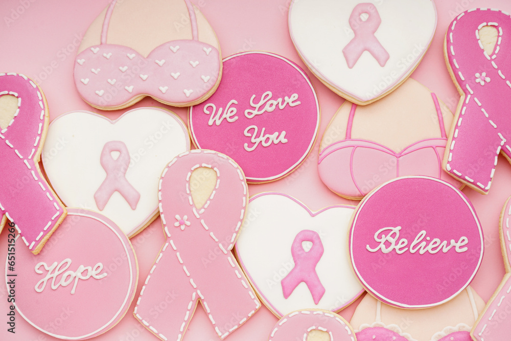 Cookies with ribbons and supportive words on pink background. Breast cancer awareness concept