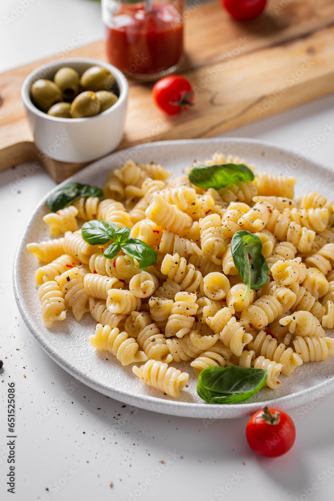 Plate with italian pasta on a white kitchen table Plate with italian pasta on a white kitchen table