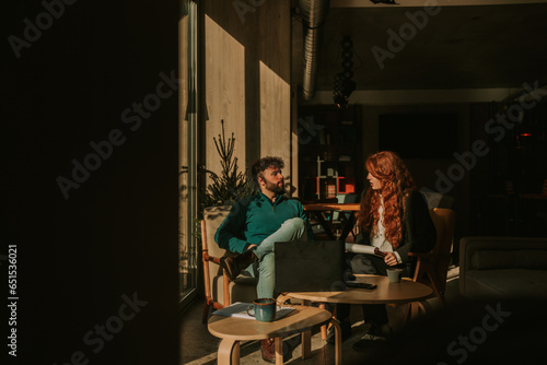 Front view photo of lovely business couple working together at the cafe on a beautiful sunny morning