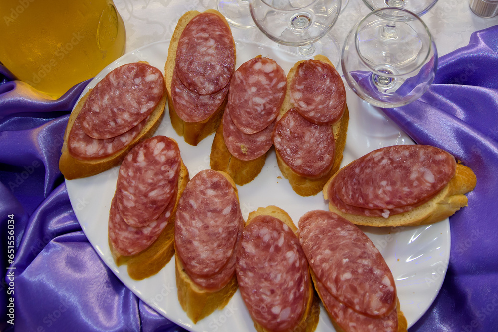 Sandwiches with smoked sausage. The food is varied and appetizing for a banquet.