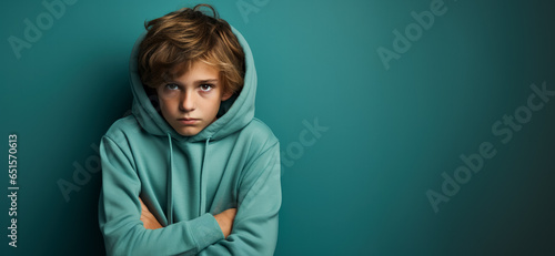 A shy child looking down isolated on a cool-toned gradient background 